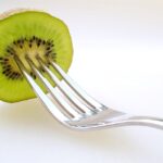 Due kiwi freschi su un tavolo, simbolo di una dieta quotidiana e delle sue possibili conseguenze.