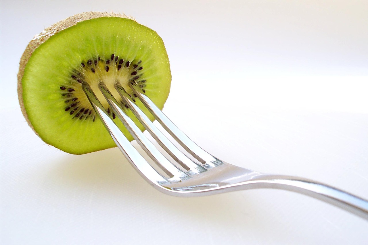 Due kiwi freschi su un tavolo, simbolo di una dieta quotidiana e delle sue possibili conseguenze.