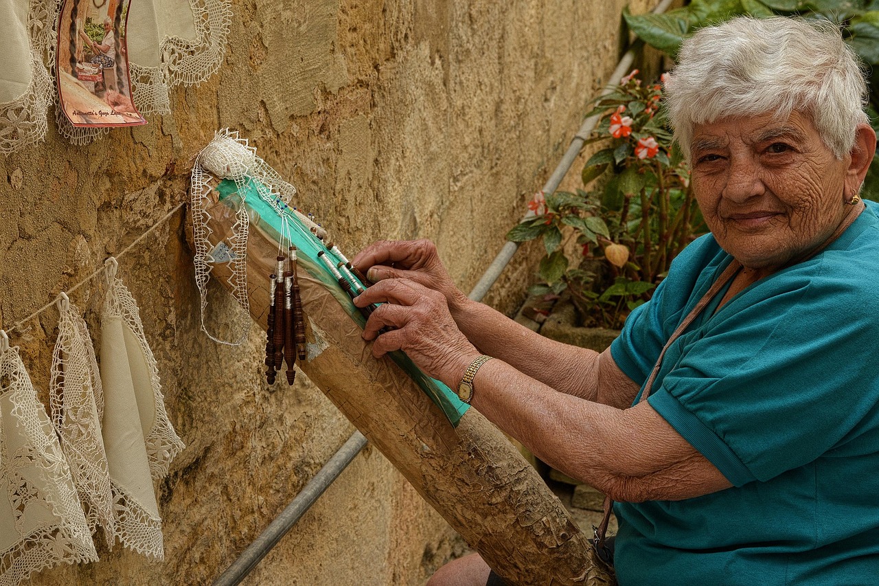 Vecchi merletti e pizzi artigianali della nonna, simbolo di tradizione e valore, esposti su un tavolo.