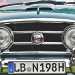 Immagine di un'auto d'epoca con un cartello che indica "esenzione bollo auto 2026" per veicoli storici.