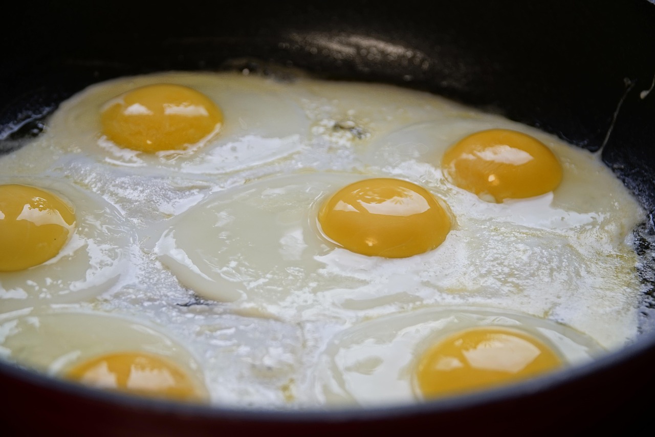 Uova in cottura in una pentola, con fumi e vapore che si alzano.